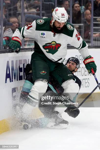 Jordan Eberle of the Seattle Kraken crashes into the boards against Zach Bogosian of the Minnesota Wild during the second period at Climate Pledge...