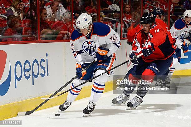 Ales Hemsky of the Edmonton Oilers battles for the puck against John Carlson of the Washington Capitals in the first period during an NHL game at...