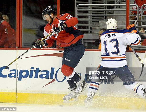 Washington Capitals defenseman Mike Green steps away from a check by Edmonton Oilers right wing Mike Brown in the first period at the Verizon Center...