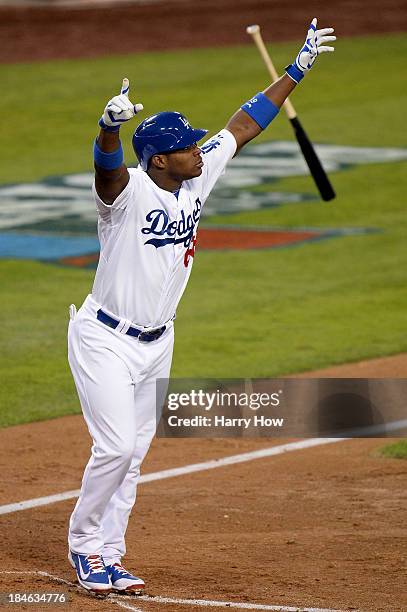 Yasiel Puig of the Los Angeles Dodgers reacts as he hits a RBI triple in the fourth inning against the St. Louis Cardinals in Game Three of the...