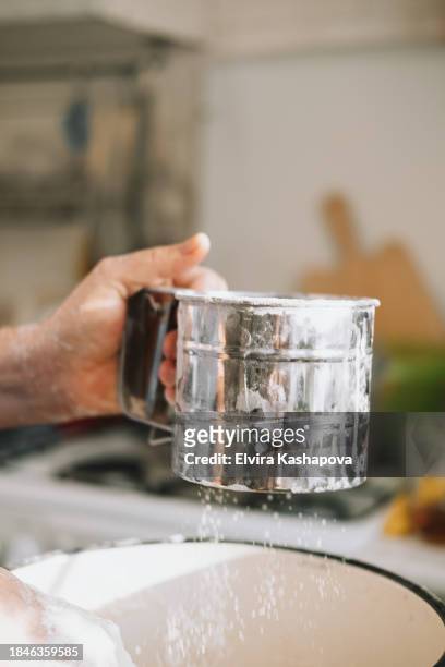 grind flour in an iron calico mug. atmospheric photo of flour - powdered sugar sifter fotografías e imágenes de stock