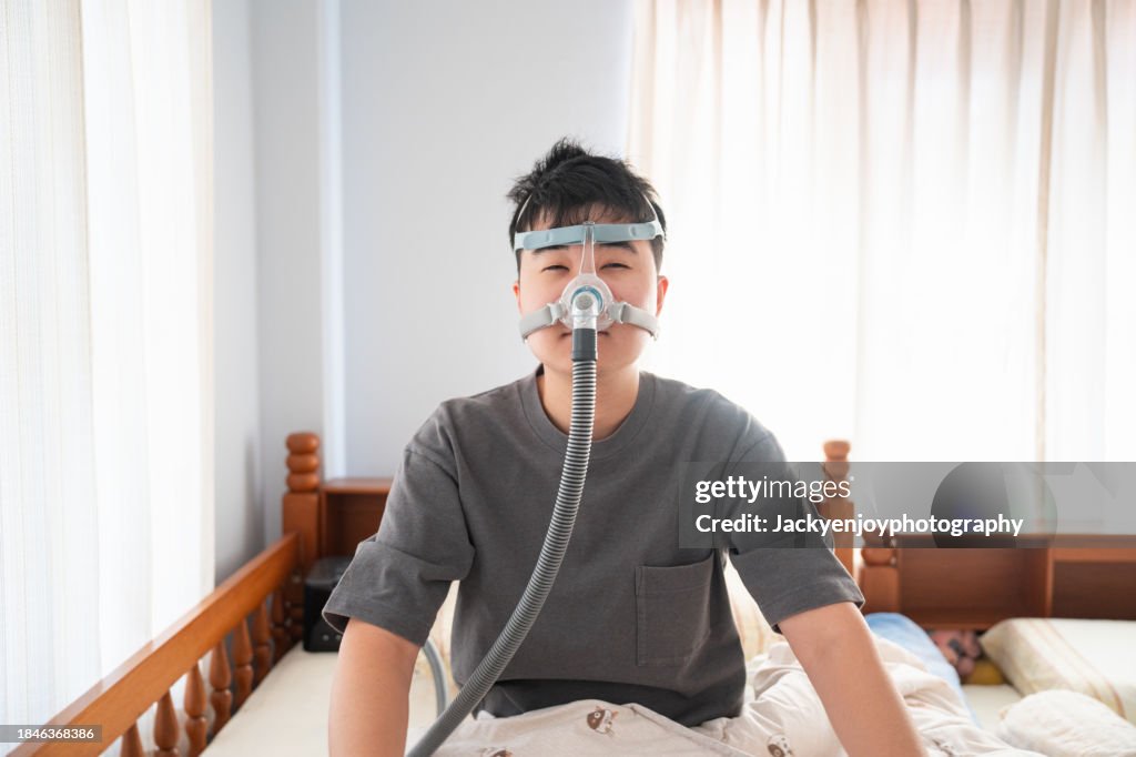 Man suffering from obstructive sleep apnea and sleeping with a Cpap mask
