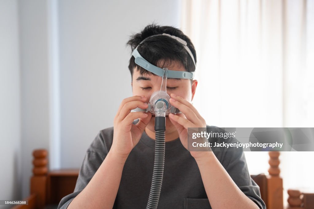 Man with tubes encircling him and using a CPAP machine