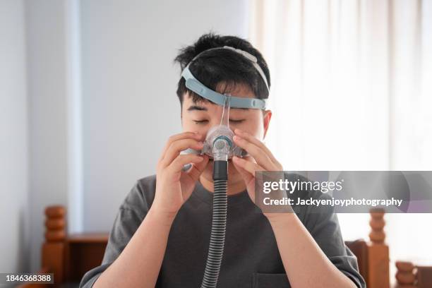 man with tubes encircling him and using a cpap machine - person on ventilator stock pictures, royalty-free photos & images