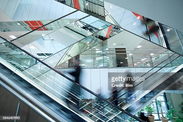 people on two crossed escalators, blurred motion - shopping centre escalator stock pictures, royalty-free photos & images