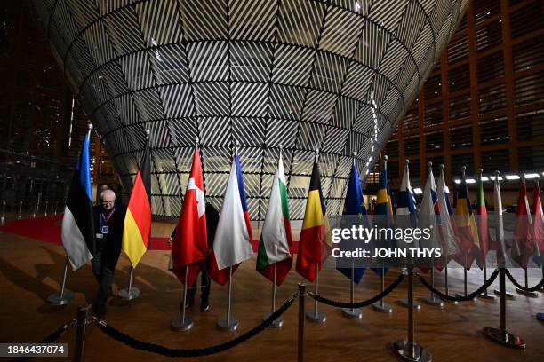 Worker puts out the flags of European nations ahead of the arrival of European leaders for the EU-Western Balkans summit at the European headquarters...