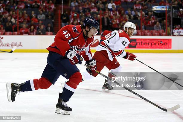 Michael Latta of the Washington Capitals and Brett Sutter of the Carolina Hurricanes go after the puck at Verizon Center on October 10, 2013 in...