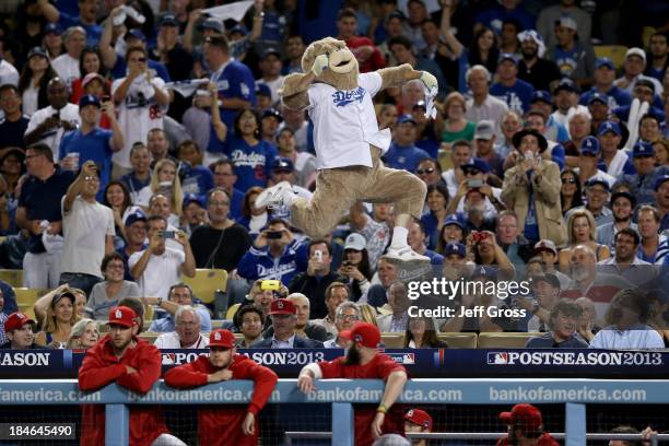 Fan dressed as a bear dances on the St. Louis Cardinals dugout in the eighth inning as the Cardinals take on the Los Angeles Dodgers in Game Three of...