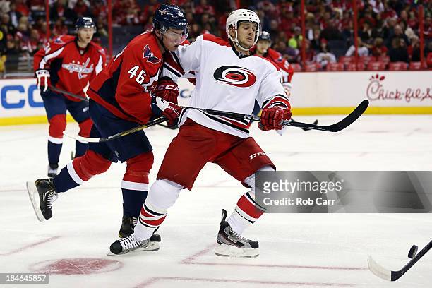 Michael Latta of the Washington Capitals and Brett Sutter of the Carolina Hurricanes skate after the puck at Verizon Center on October 10, 2013 in...