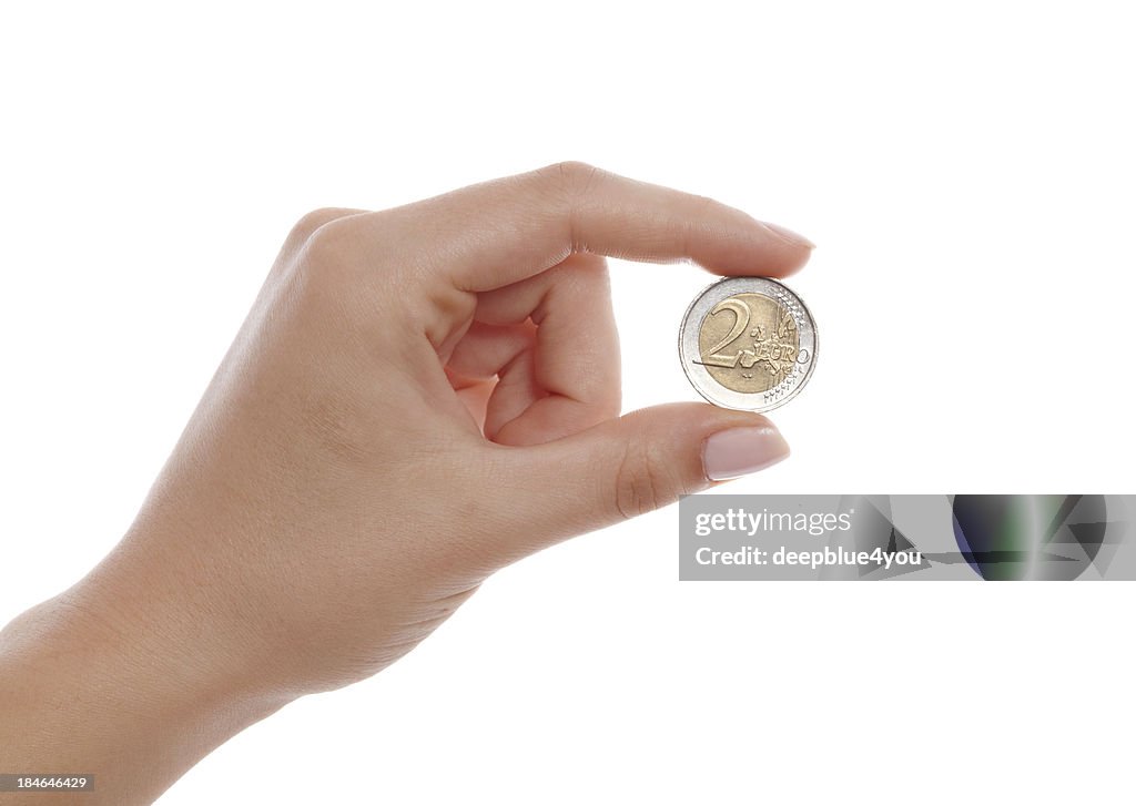 Woman finger holding two euro coin isolated on white