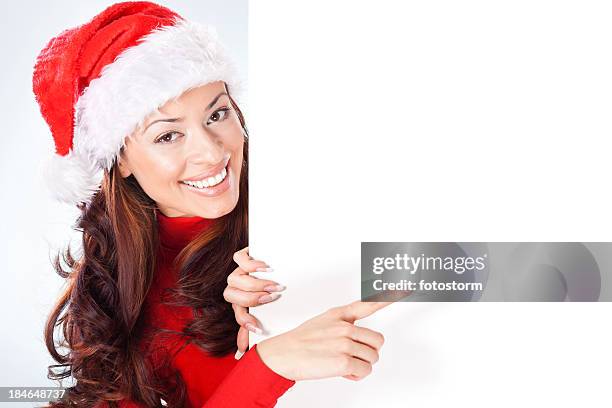 mulher com chapéu de santa apontando no banner em branco - mãe natal imagens e fotografias de stock