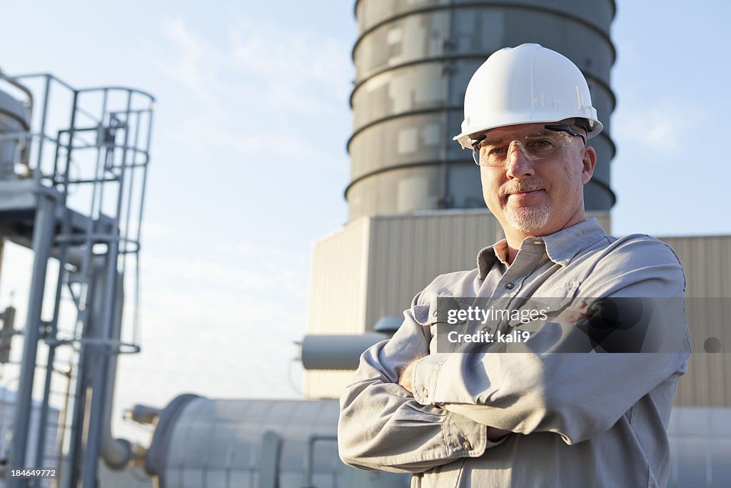 Ingenieur mit Bauarbeiterhelm auf industrial Center