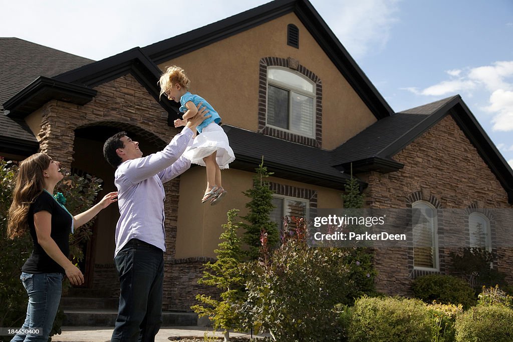 Cute Young Couple and Child with Beautiful Home