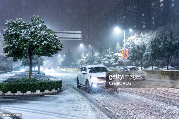 Vehicles are driven on a road during a snowfall on December 10, 2023 in Yuncheng, Shanxi Province of China.