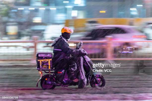 Citizen rides an electric bicycle during a snowfall on December 10, 2023 in Yuncheng, Shanxi Province of China.