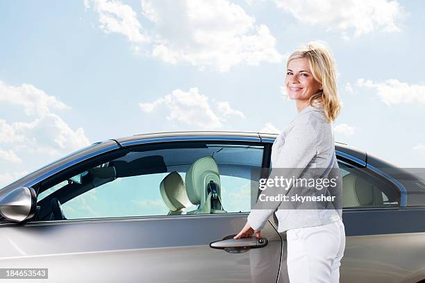 beautiful woman opening her car door. - open car door stock pictures, royalty-free photos & images