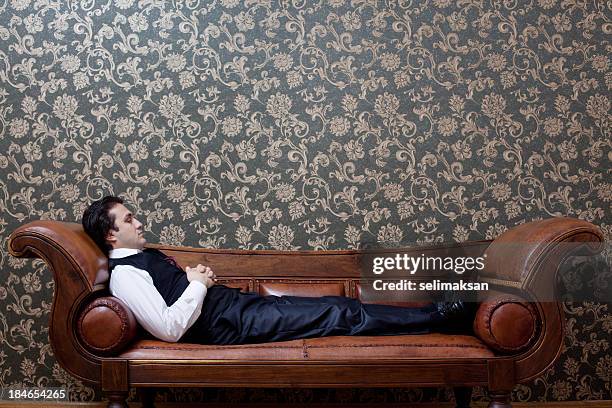 mesmerized man lying down on coach in psychiatrist office - hypnose stockfoto's en -beelden