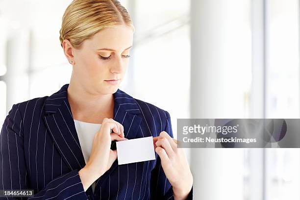 empresária ajustando uma etiqueta de identificação - trabalhadora de colarinho branco - fotografias e filmes do acervo