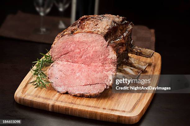 prime rib roast on a cutting board ready to be sliced - beef ribs stock pictures, royalty-free photos & images