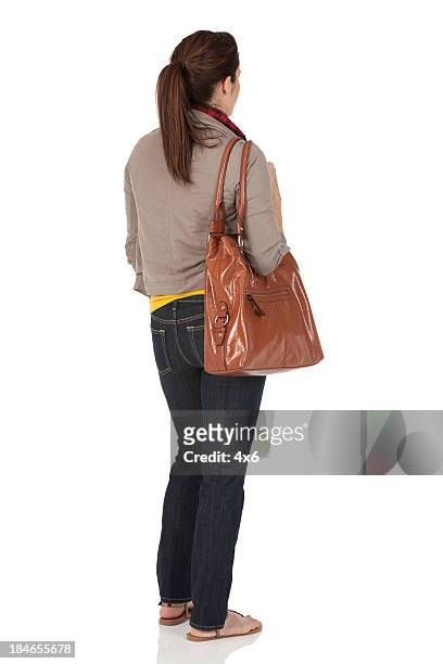 woman carrying a bag - brunette woman back stockfoto's en -beelden