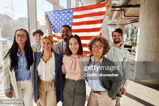 Happy business colleagues with the American flag in the office.