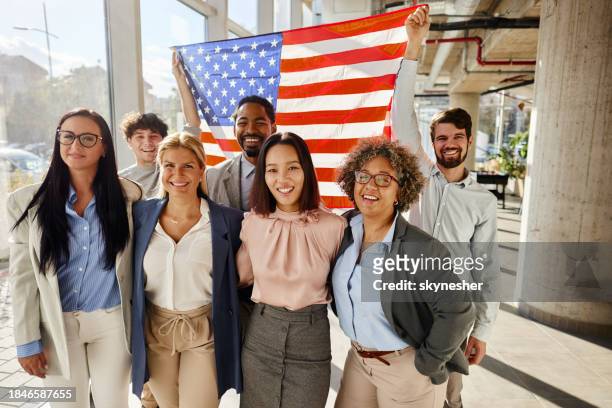 happy business colleagues with the american flag in the office. - conservative politics stock pictures, royalty-free photos & images