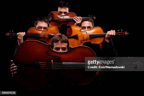 a string quartet on a dark background - musical quartet stock pictures, royalty-free photos & images