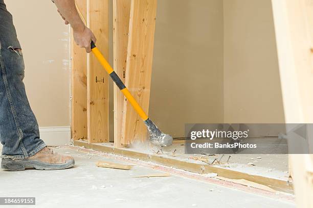 construction worker using a sledgehammer to remove wall stud - swinging sledgehammer stock pictures, royalty-free photos & images