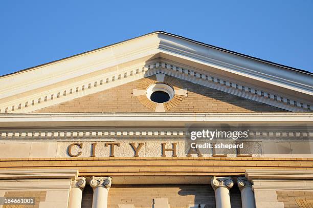 a sign showing city hall on a building  - guildhall stock pictures, royalty-free photos & images