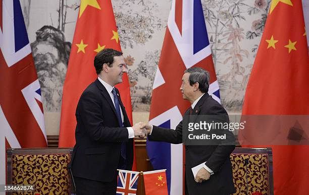 Britain's Chancellor of the Exchequer George Osborne shakes hands with Chinese Vice premier Ma Kai after a signing ceremony at the Diaoyutai...