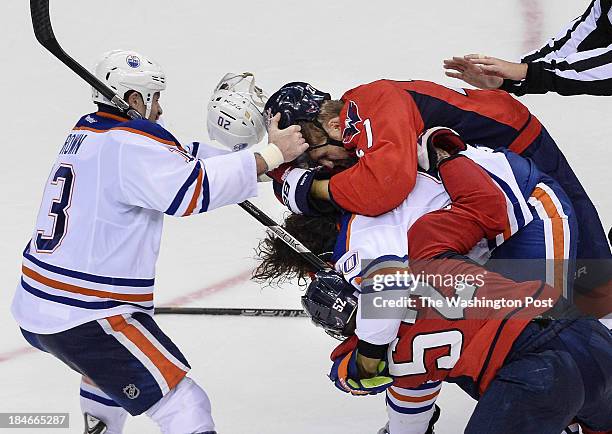 Edmonton Oilers right wing Mike Brown , right, tries to pull off Washington Capitals defenseman Karl Alzner's helmet as Washington Capitals...