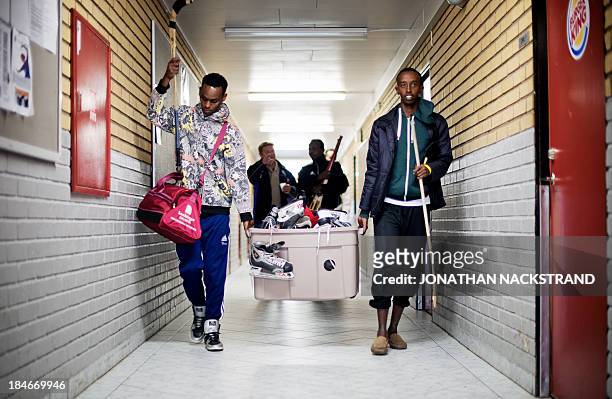 Somali players carry their national Bandy team's equipment after their training session on September 24, 2013 in the city of Borlaenge, Sweden....