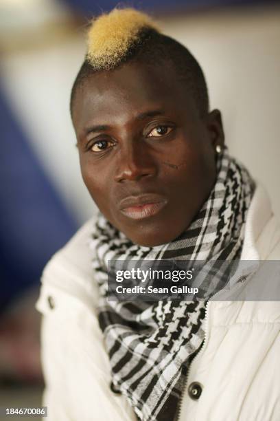 Abidal who is a refugee from Burkina Faso, poses for a photograph in a tent at the makeshift camp where he and approximately 100 other refugees are...