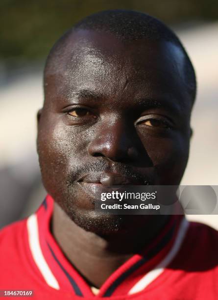 Modibo Traore who is a refugee from Mali, poses for a photograph next to tents at the makeshift camp where he and approximately 100 other refugees...