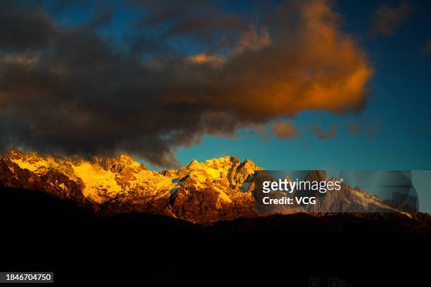 Golden sun rays shine over the Yulong Snow Mountain on December 10, 2023 in Lijiang, Yunnan Province of China.