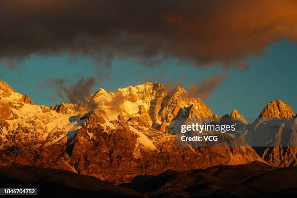 Golden sun rays shine over the Yulong Snow Mountain on December 10, 2023 in Lijiang, Yunnan Province of China.