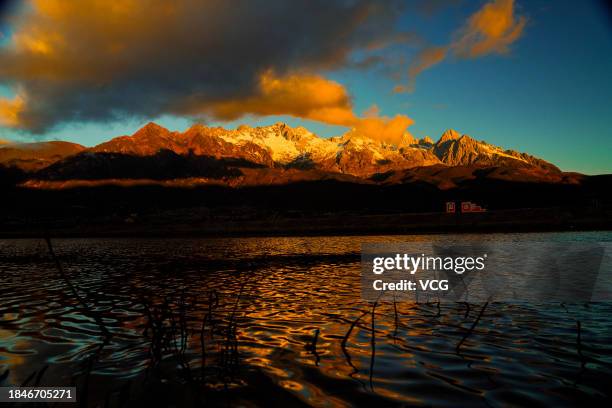 Golden sun rays shine over the Yulong Snow Mountain on December 10, 2023 in Lijiang, Yunnan Province of China.