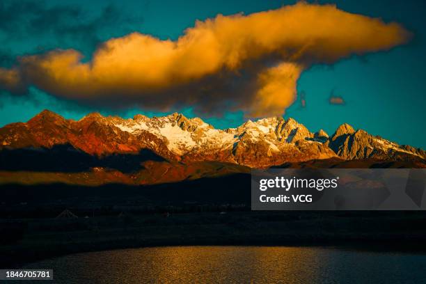 Golden sun rays shine over the Yulong Snow Mountain on December 10, 2023 in Lijiang, Yunnan Province of China.