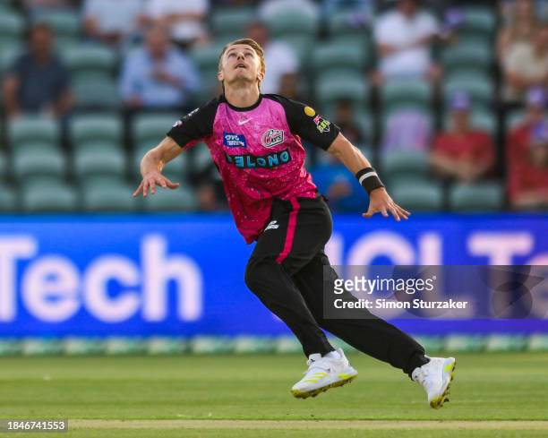 Tom Curran of the Sixers attempts to catch a ball off his own bowlingduring the BBL match between Hobart Hurricanes and Sydney Sixers at University...