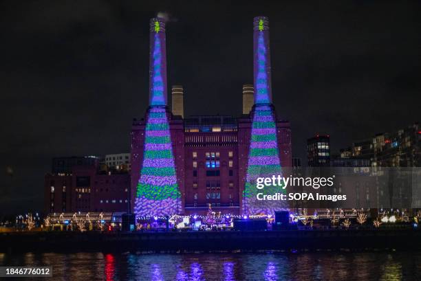 British artist David Hockney projects two animated Christmas trees onto the iconic chimneys of the Battersea Power Station in London. British...
