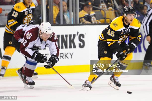 David Krejci of the Boston Bruins skates with the puck against Gabriel Landeskog of the Colorado Avalanche at the TD Garden on October 10, 2013 in...