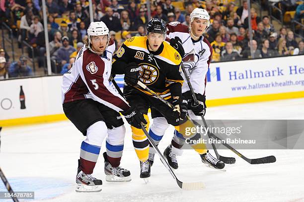 Jordan Caron of the Boston Bruins watches the play against Nate Guenin and Paul Stastny of the Colorado Avalanche at the TD Garden on October 10,...