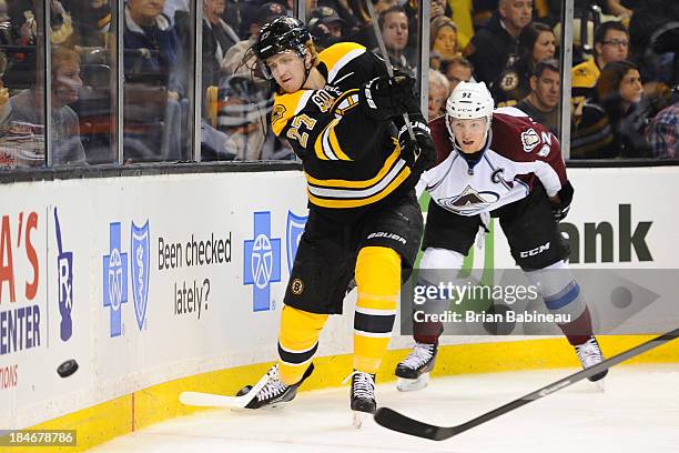 Dougie Hamilton of the Boston Bruins dumps the puck around the boards against Gabriel Landeskog of the Colorado Avalanche at the TD Garden on October...