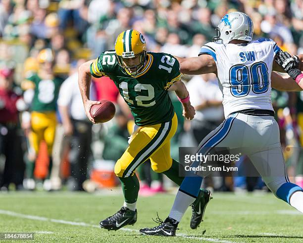 Aaron Rodgers of the Green Bay Packers gets away from Ndamukong Suh of the Detroit Lions defense at Lambeau Field on October 6, 2013 in Green Bay,...