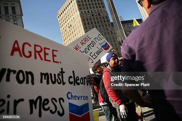 Following an $18 billion judgment against Chevron from a court in Ecuador, protesters, some in traditional dress and with black hands representing...