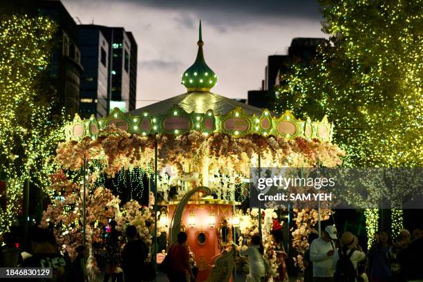 People gather as part of holiday festivites ahead of Christmas in front of the Taipei 101 commercial building in Taipei on December 14, 2023.