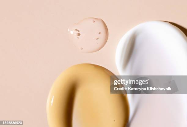 cosmetic products samples smears of cream mask serum for face care cosmetics on a beige background - gezichtscrème stockfoto's en -beelden