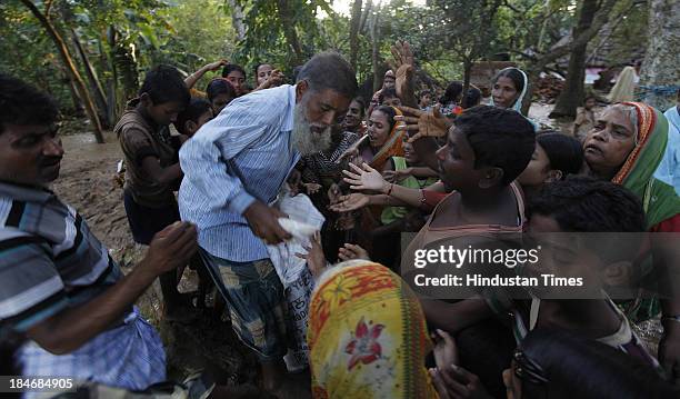 Unnyan distributing ready food to Villagers of Gopinath Pura, who are staying near Subarnarekha River after the cyclone Phailin on October 15, 2013...
