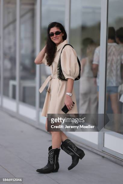 Isabella Gosen seen wearing Le Specs brown tortoise oval sunglasses, gold earrings, beige linen belted short dress with puff sleeves, silver watch,...