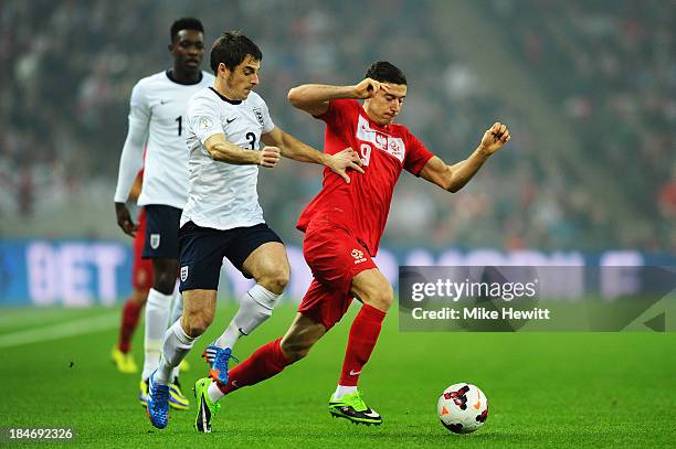 Robert Lewandowski of Poland is challenged by Leighton Baines of England during the FIFA 2014 World Cup Qualifying Group H match between England and...